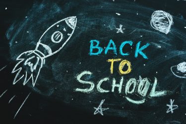 Space rocket with planets and stars doodle drawing on chalkboard, back to school concept