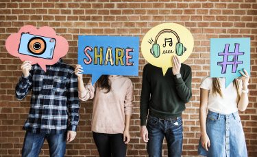 Friends holding up thought bubbles with social media concept icons