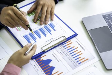 Marketers and financial accountants are discussing and analyzing charts to plan strategies to meet customer needs, Brainstorm teams, Team meetings, or business