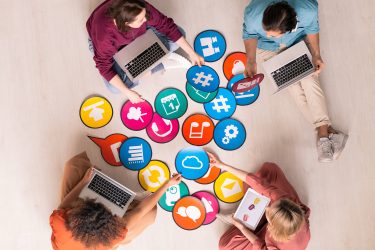Aerial view of colleagues on laptops sitting on the floor beside eachother